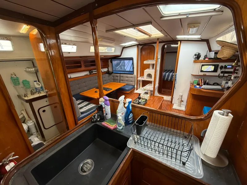 Slide: The Image of Interior of 1986 Beneteau Idylle 15.50 yacht with kitchen, dining area, and cozy living space. - 30