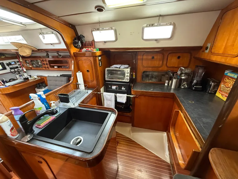 Slide: The Image of Interior of 1986 Beneteau Idylle 15.50 yacht kitchen with wooden cabinetry and appliances. - 31