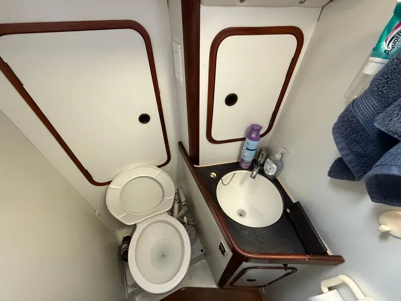 Slide: The Image of Compact bathroom in a 1986 Beneteau Idylle 15.50 sailboat, featuring a toilet and sink. - 36