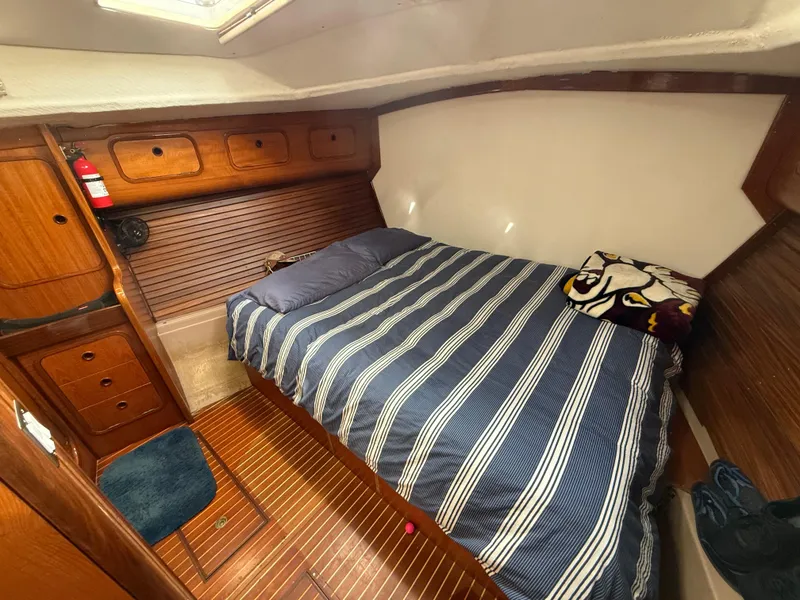 Slide: The Image of Cozy cabin interior of 1986 Beneteau Idylle 15.50 sailboat with striped bedding and wooden finish. - 44