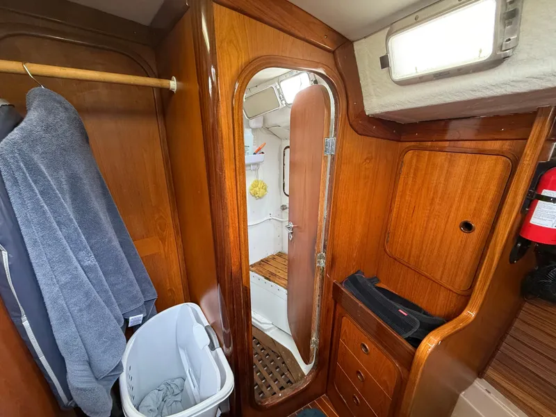 Slide: The Image of Interior of 1986 Beneteau Idylle 15.50 sailboat with wooden cabinetry and bathroom view. - 46