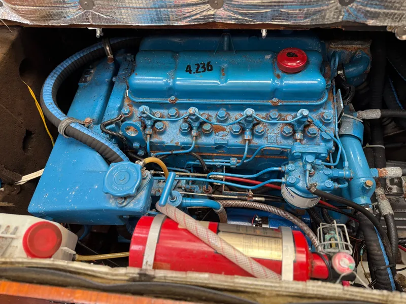 Slide: The Image of Blue engine of a 1986 Beneteau Idylle 15.50 sailboat, featuring a red fire extinguisher. - 48