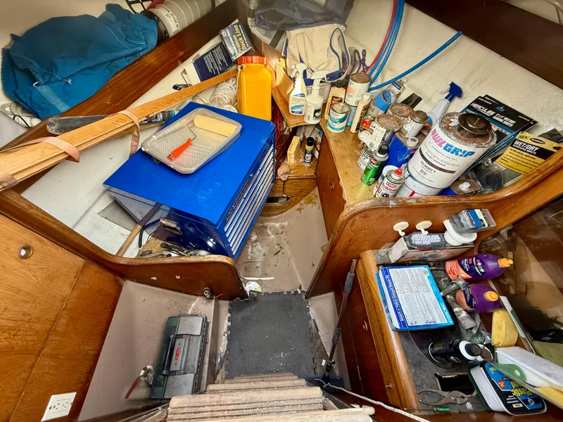 Slide: The Image of Interior of 1986 Beneteau Idylle 15.50 sailboat with tools and supplies stored. - 49