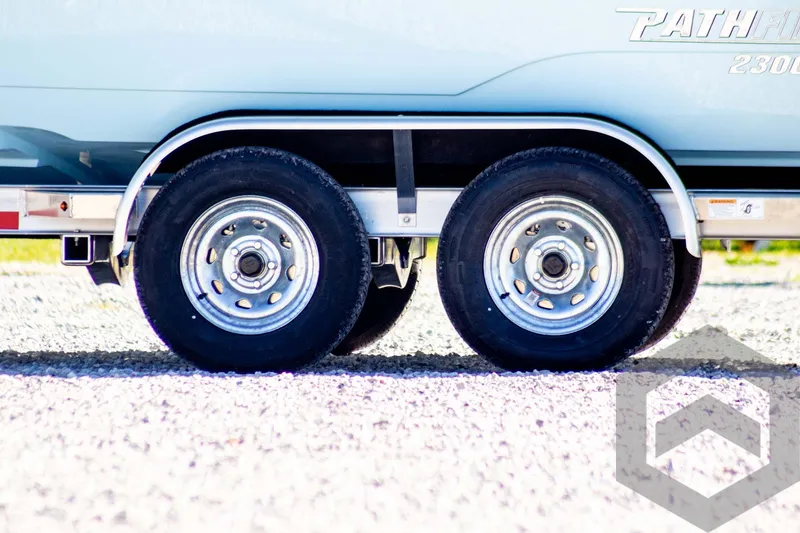 Slide: The Image of 2025 Pathfinder 2300 HPS trailer wheels on gravel surface. - 10