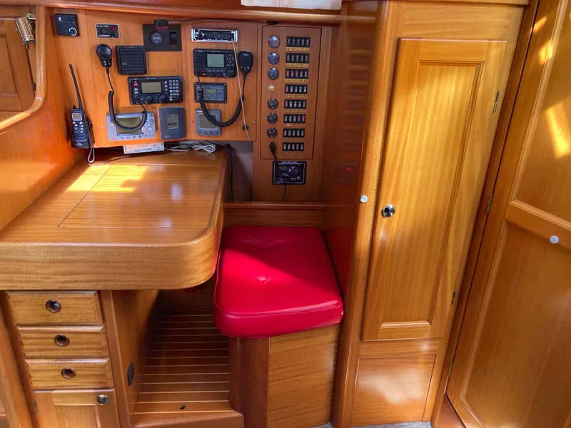 Slide: The Image of Navigation station in a 2001 Malo 43 yacht with wooden cabinetry and red cushioned seat. - 17