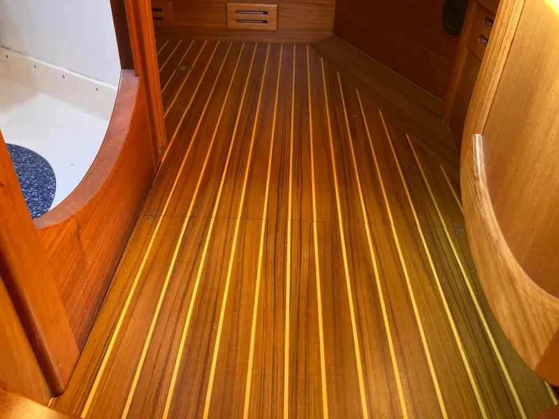 Slide: The Image of Wooden interior flooring of a 2001 Malo 43 boat, featuring sleek, polished finish. - 24