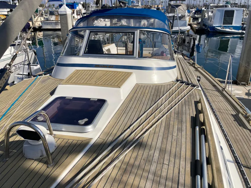 Slide: The Image of Sailboat Malo 43, 2001 model, docked in marina with wooden deck and blue canopy. - 31