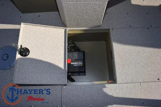 Slide: The Image of 2025 Lund 1875 Alaskan SS boat storage compartment with battery charger, Thayer's Marine logo. - 24