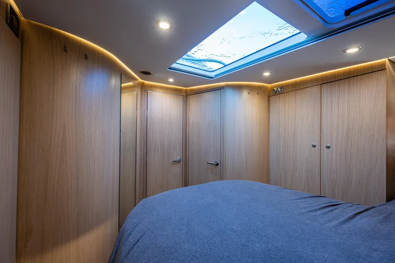 Slide: The Image of Luxurious interior of 2024 Nimbus 405 Flybridge yacht with wood paneling and skylight. - 15