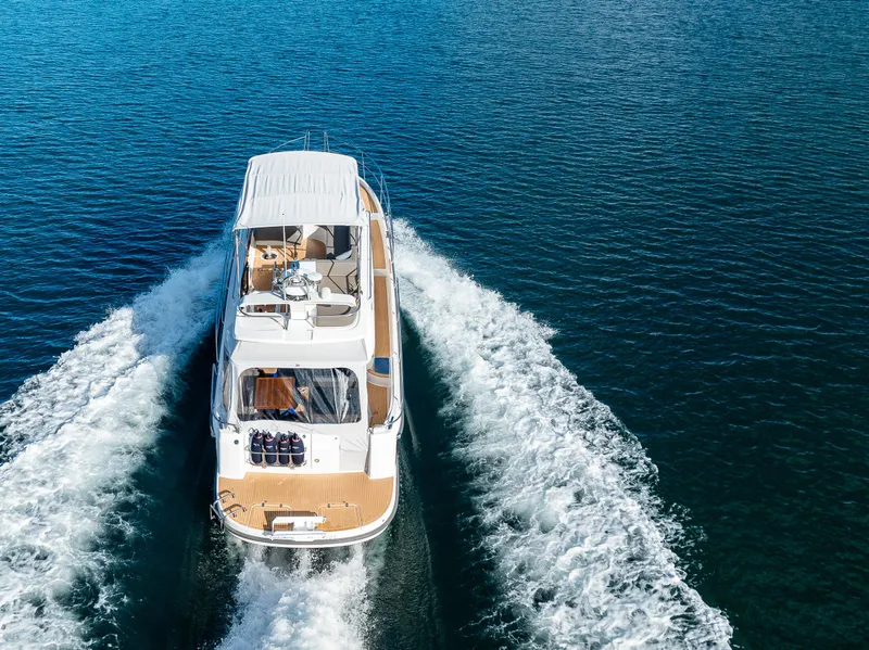 Slide: The Image of 2024 Nimbus 405 Flybridge cruising on open water, aerial view. - 2