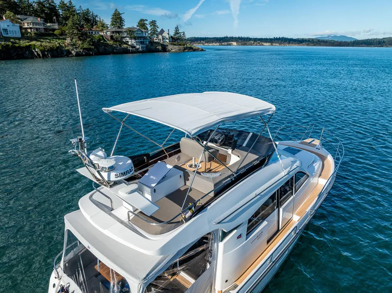 Slide: The Image of 2024 Nimbus 405 Flybridge yacht cruising on a serene blue lake. - 28