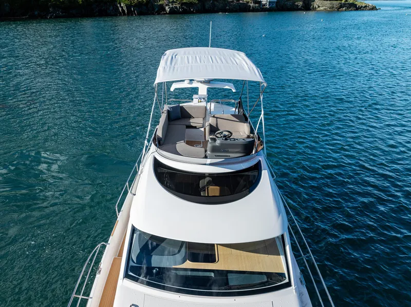 Slide: The Image of 2024 Nimbus 405 Flybridge yacht on serene blue water, showcasing elegant design and spacious deck. - 31