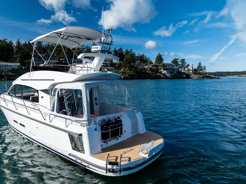 Slide: The Image of 2024 Nimbus 405 Flybridge yacht on serene blue water under a clear sky. - 36