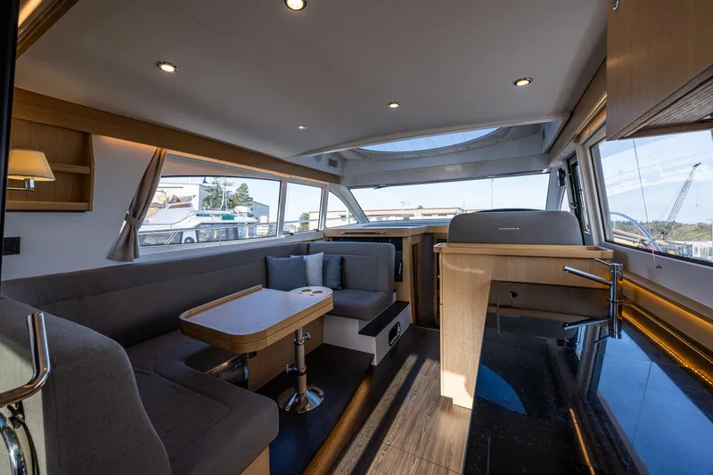 Slide: The Image of Luxurious interior of 2024 Nimbus 405 Flybridge yacht with modern seating and panoramic windows. - 4