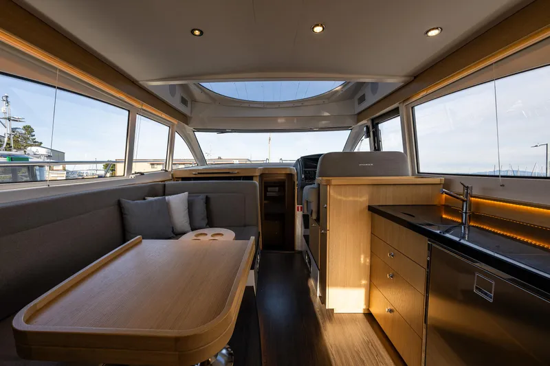 Slide: The Image of Luxurious interior of 2024 Nimbus 405 Flybridge yacht with modern kitchen and seating area. - 5