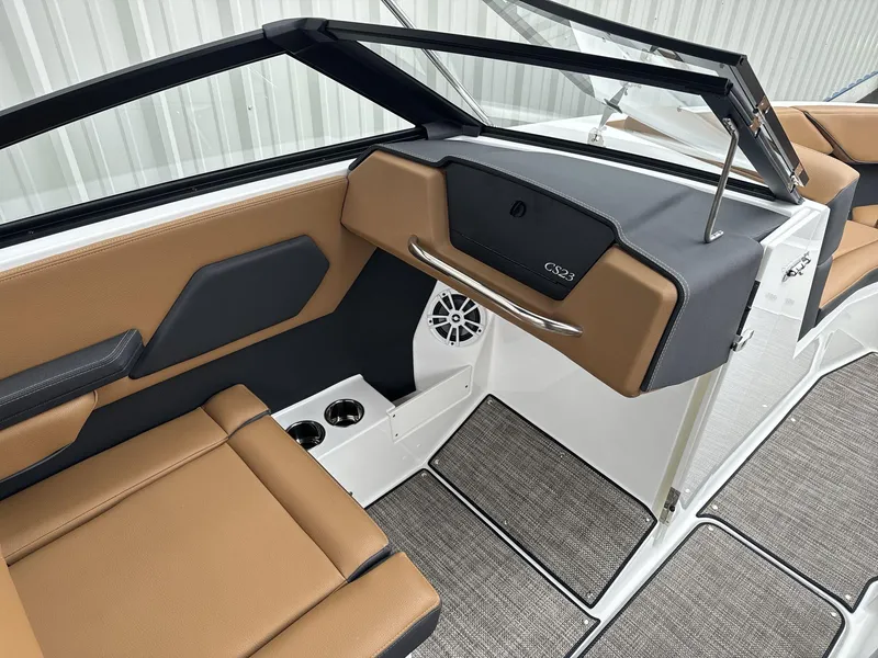 Slide: The Image of 2025 Cobalt CS23 boat interior with tan and black seating, modern design, and cup holders. - 11