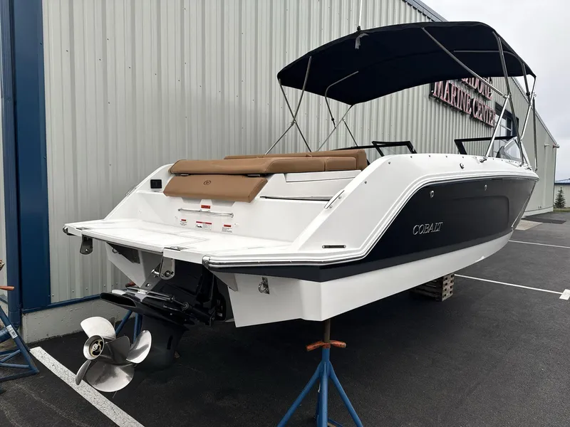 Slide: The Image of 2025 Cobalt CS23 boat with canopy, displayed on stands outside a marine center. - 4