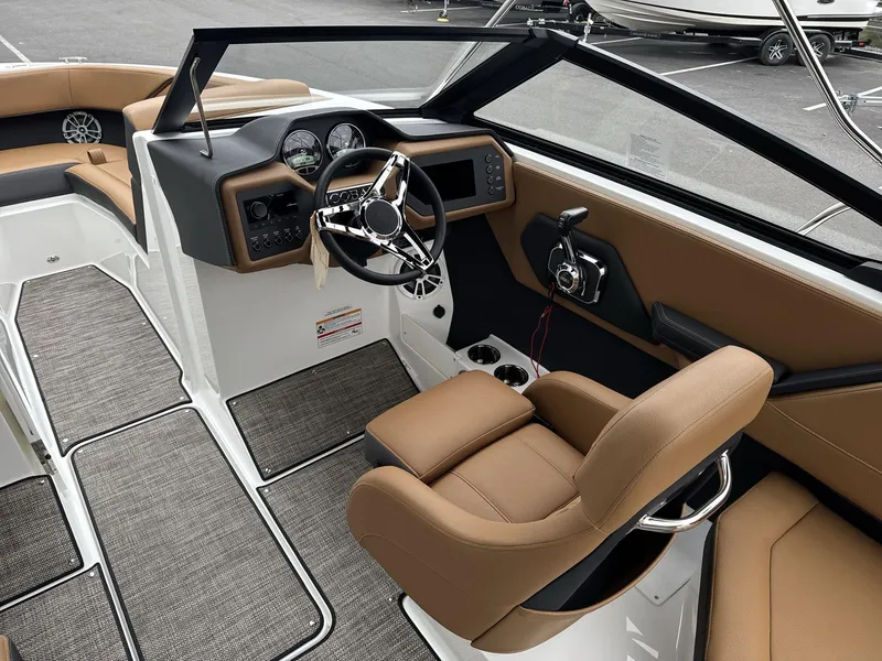 Slide: The Image of 2025 Cobalt CS23 boat interior with modern dashboard and tan seating. - 9