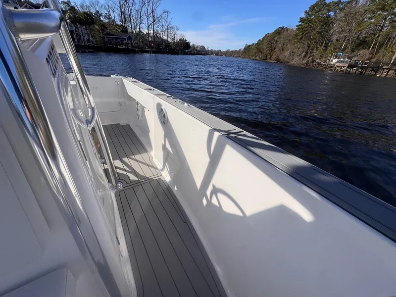 Slide: The Image of 2024 Aquasport 2200 Center Console boat on a serene river. - 10