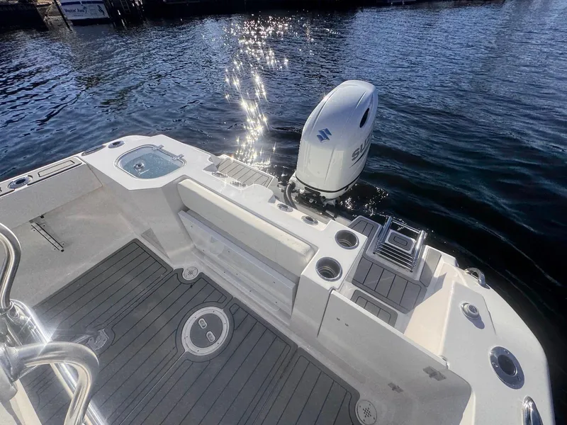 Slide: The Image of 2024 Aquasport 2200 Center Console boat with Suzuki outboard engine on water. - 14