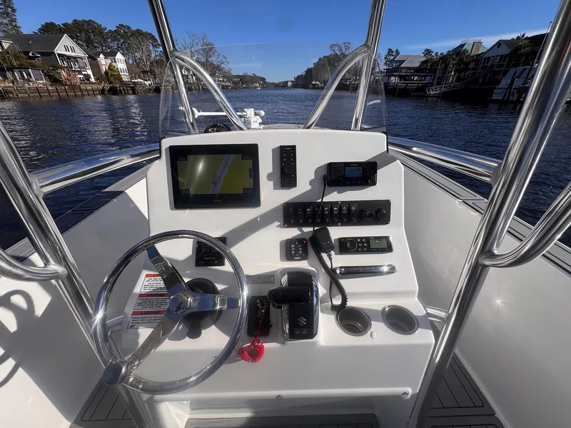Slide: The Image of 2024 Aquasport 2200 Center Console boat dashboard on a scenic waterway. - 18