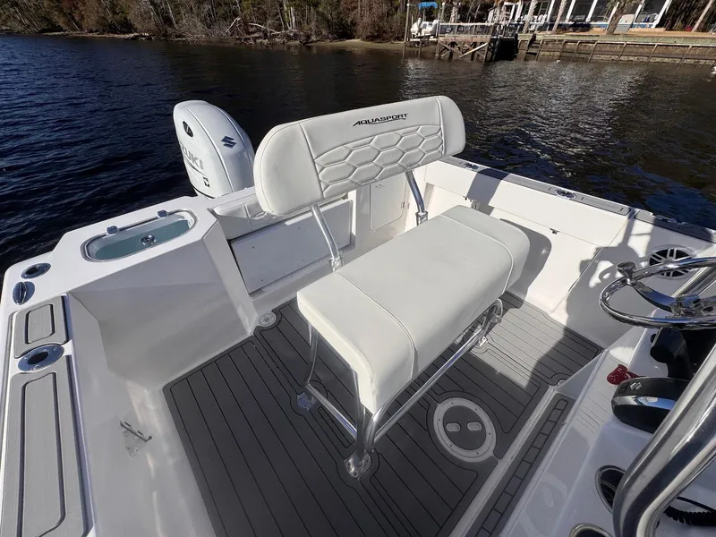 Slide: The Image of 2024 Aquasport 2200 Center Console boat interior with seating and steering wheel. - 21