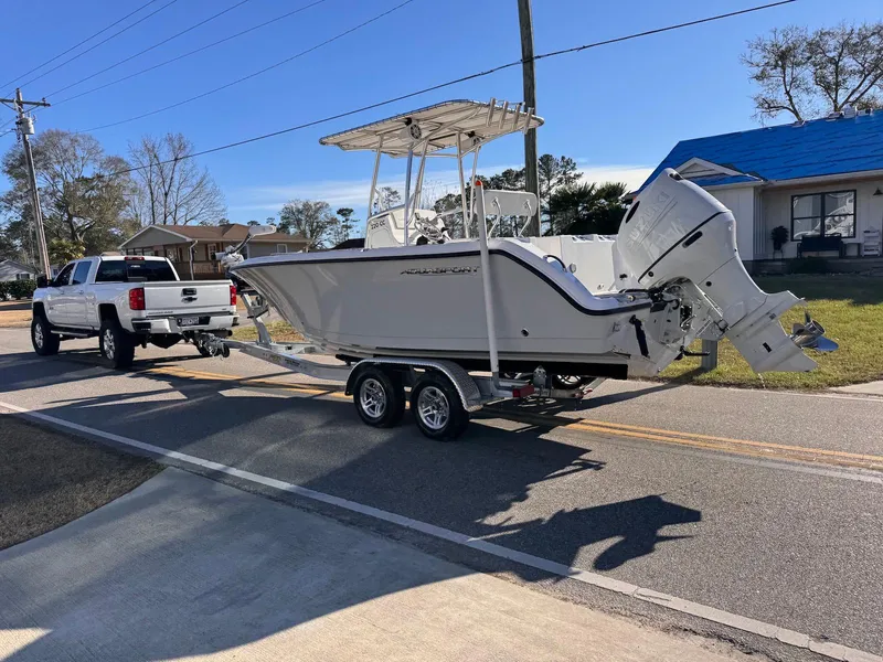 Slide: The Image of 2024 Aquasport 2200 Center Console boat on trailer, towed by a white truck. - 30