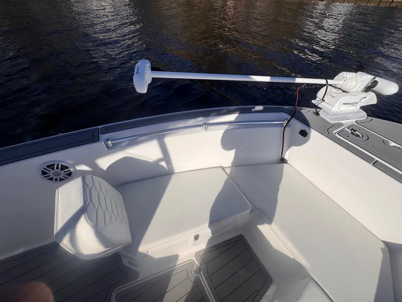 Slide: The Image of 2024 Aquasport 2200 Center Console boat interior with seating and trolling motor. - 8