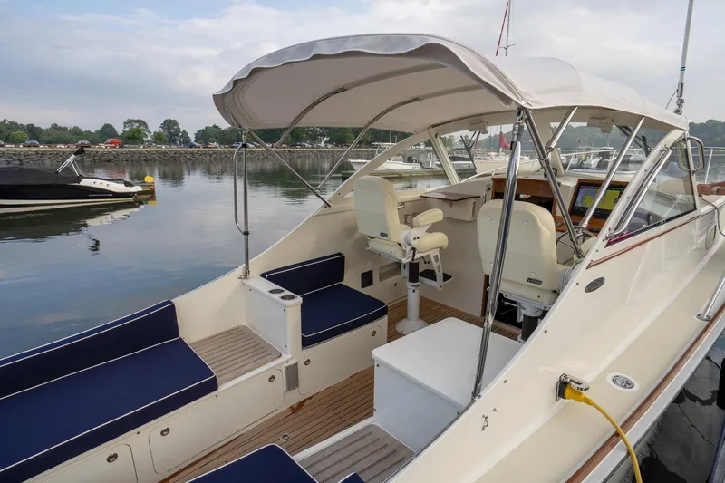 Slide: The Image of 2021 Brooklin Boat Yard 32 Express with spacious seating and modern helm, docked by calm waters. - 10