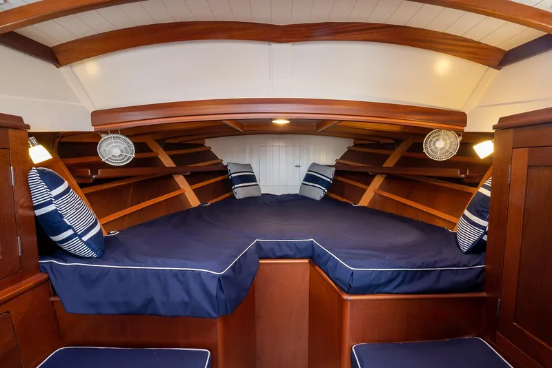 Slide: The Image of Luxurious cabin interior of 2021 Brooklin Boat Yard 32 Express with blue cushions and wood finish. - 12