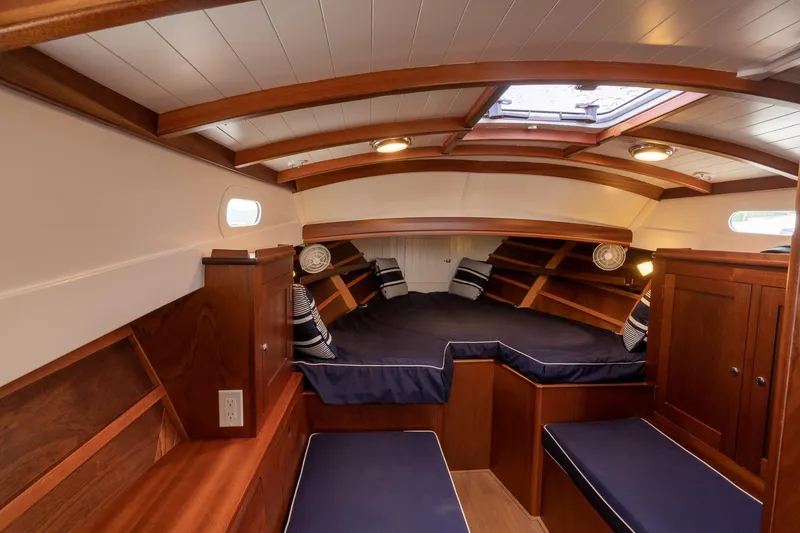 Slide: The Image of Luxurious cabin interior of 2021 Brooklin Boat Yard 32 Express, featuring elegant wood finish and cozy bedding. - 13