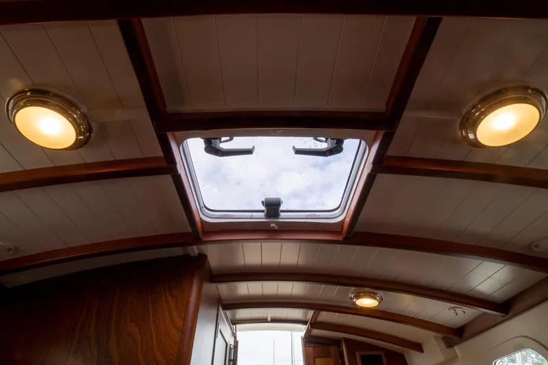 Slide: The Image of Interior view of 2021 Brooklin Boat Yard 32 Express, featuring wooden ceiling and skylight. - 17