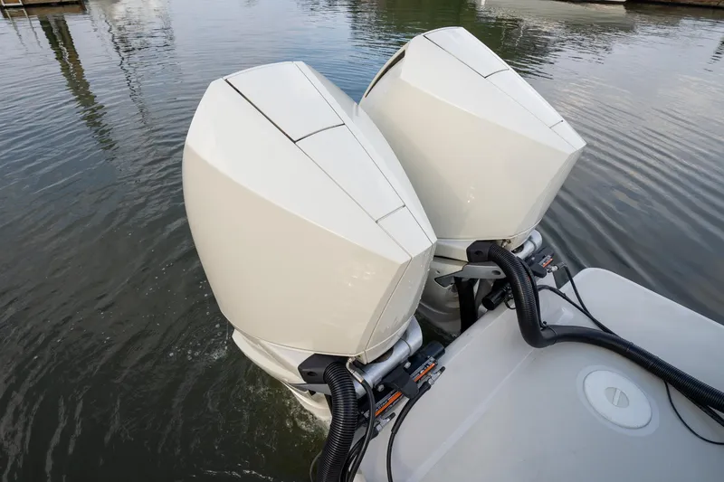Slide: The Image of Twin outboard engines on a 2021 Brooklin Boat Yard 32 Express, docked on calm water. - 27