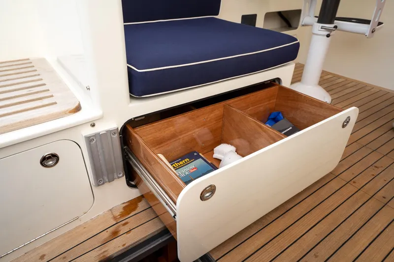 Slide: The Image of Storage drawer on 2021 Brooklin Boat Yard 32 Express, featuring wooden compartments and nautical accessories. - 35