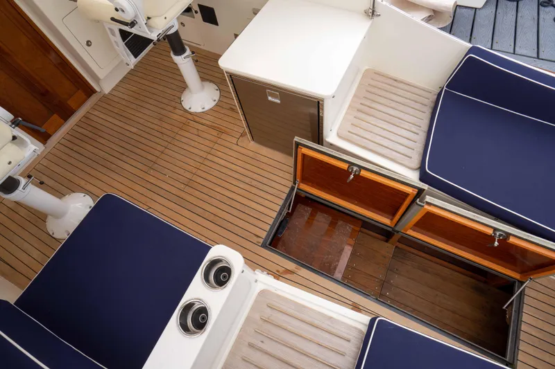 Slide: The Image of 2021 Brooklin Boat Yard 32 Express interior with wooden deck and blue cushioned seating. - 36