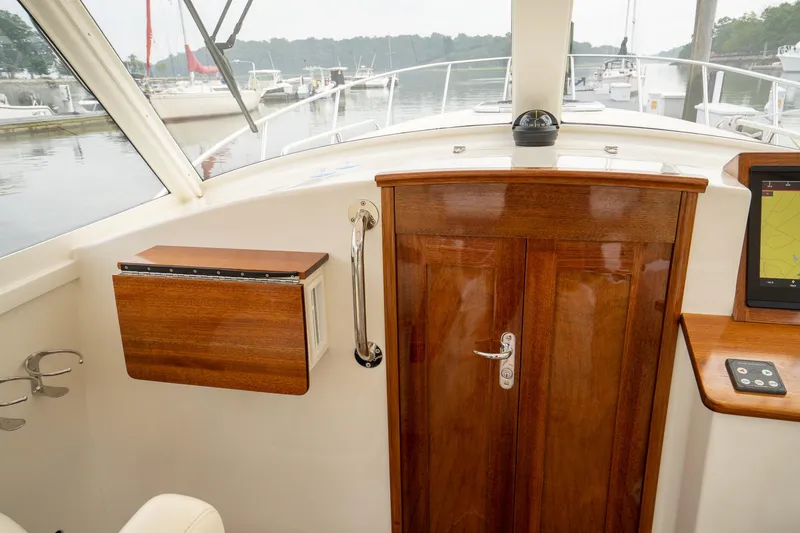 Slide: The Image of Interior view of 2021 Brooklin Boat Yard 32 Express, featuring elegant woodwork and navigation equipment. - 41
