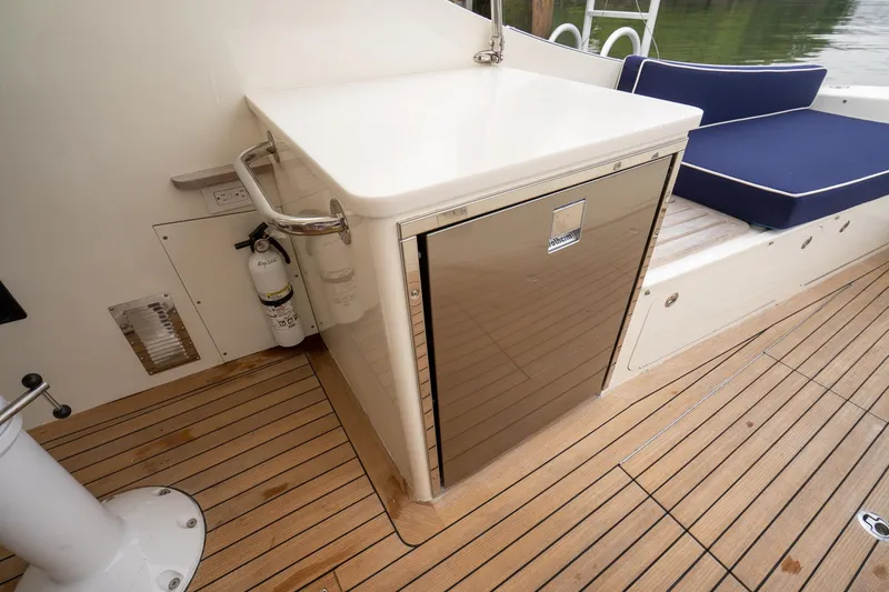 Slide: The Image of Brooklin Boat Yard 32 Express 2021 deck with seating, fridge, and wooden flooring. - 44