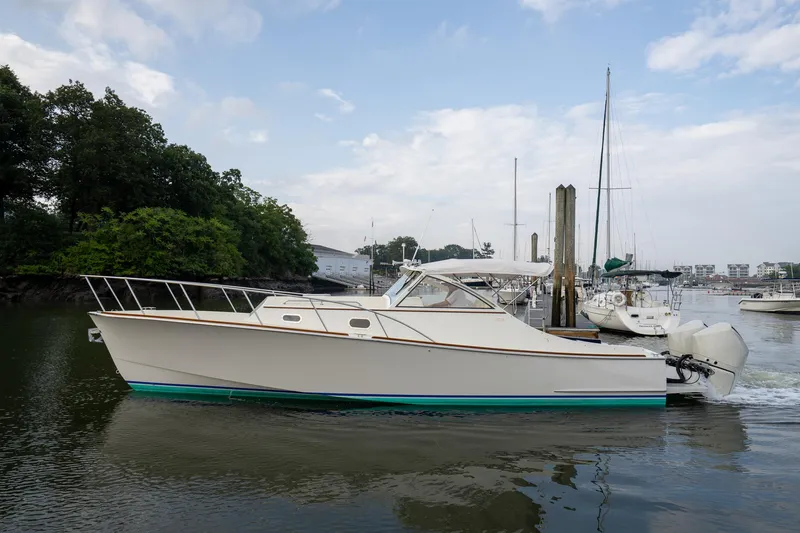Slide: The Image of 2021 Brooklin Boat Yard 32 Express cruising in a marina, surrounded by trees and other boats. - 5