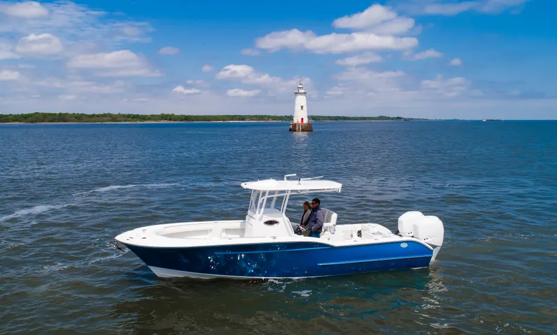 Slide: The Image of 2025 Buddy Davis 28 Center Console boat cruising near a lighthouse on a sunny day. - 10