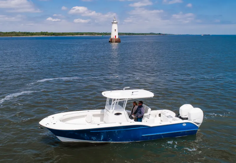 Slide: The Image of 2025 Buddy Davis 28 Center Console boat near a lighthouse on a sunny day. - 11