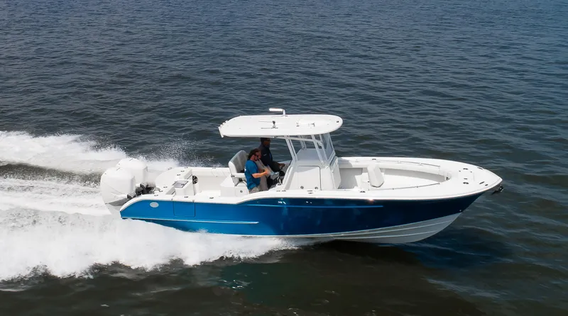 Slide: The Image of 2025 Buddy Davis 28 Center Console boat cruising on open water. - 28