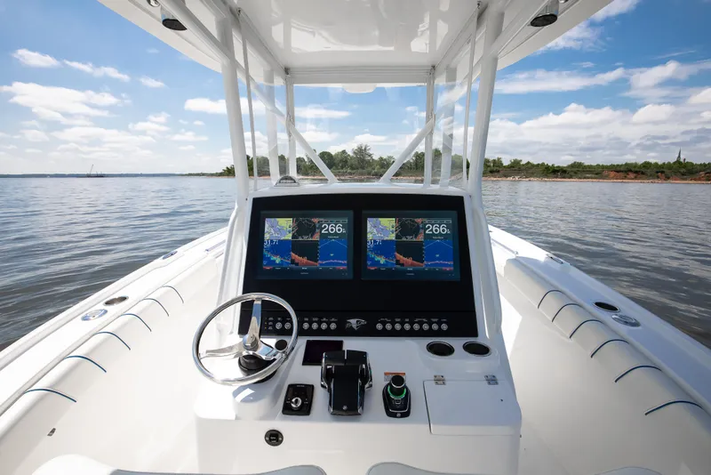 Slide: The Image of 2025 Buddy Davis 28 Center Console boat dashboard with dual navigation screens on open water. - 43