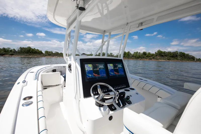 Slide: The Image of 2025 Buddy Davis 28 Center Console boat on calm water, featuring advanced navigation displays. - 45