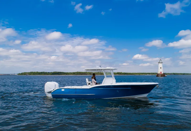 Slide: The Image of 2025 Buddy Davis 28 Center Console boat on open water near lighthouse. - 5