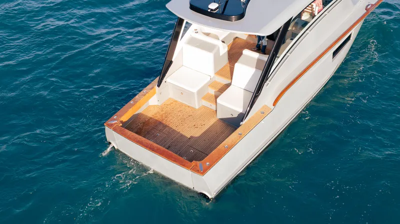 Slide: The Image of 2025 Buddy Davis 52 Express yacht on blue ocean water, showcasing sleek design and spacious deck. - 31