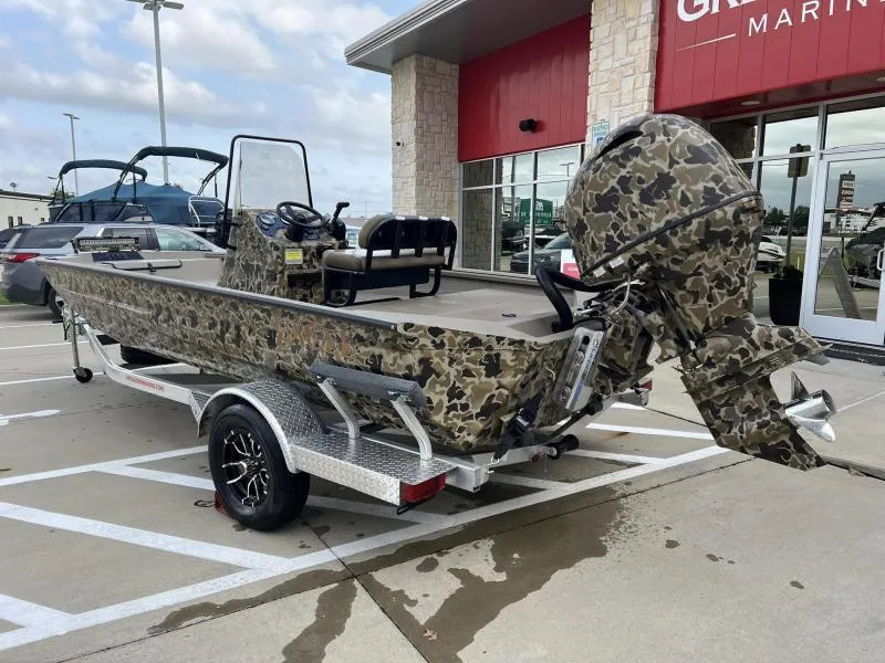 Slide: The Image of 2024 Excel Boats 1860 STALKER camo-patterned boat on trailer outside dealership. - 3