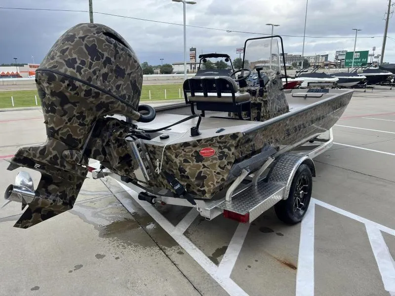 Slide: The Image of 2024 Excel Boats 1860 STALKER in camouflage design on a trailer, parked outdoors. - 4