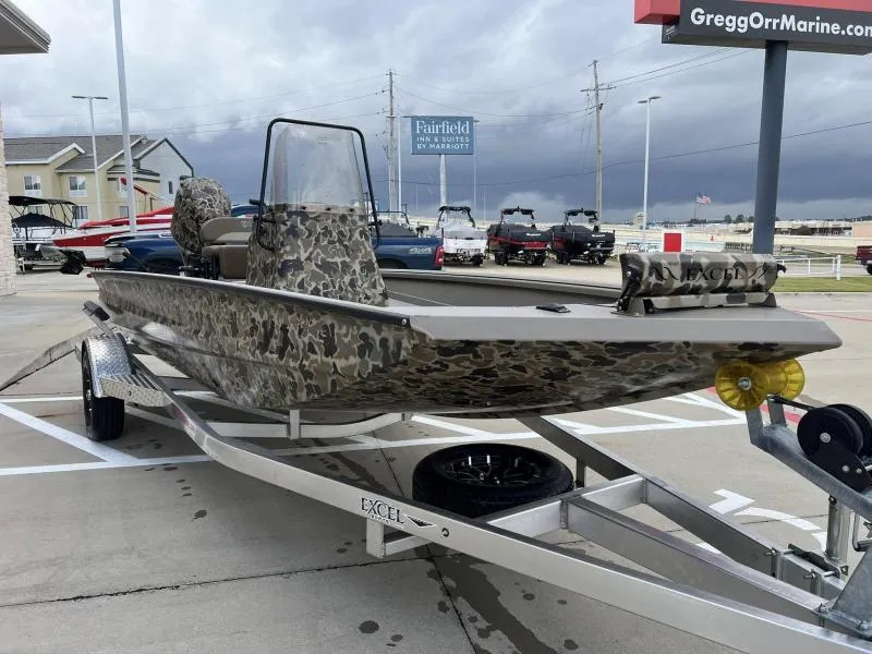 Slide: The Image of 2024 Excel Boats 1860 STALKER in camouflage design on a trailer at a dealership. - 6