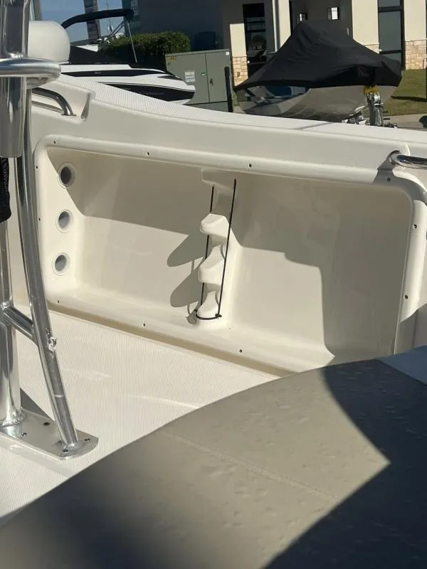 Slide: The Image of 2024 Bulls Bay 200 CC boat interior detail with storage compartment and rod holders. - 14