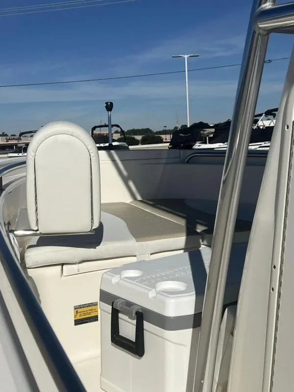 Slide: The Image of 2024 Bulls Bay 200 CC boat interior with seating and cooler under clear blue sky. - 15